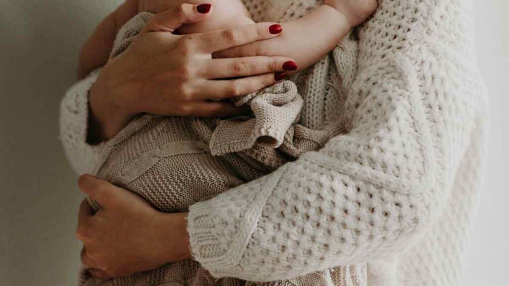 Mother holding her infant after formula feeding.