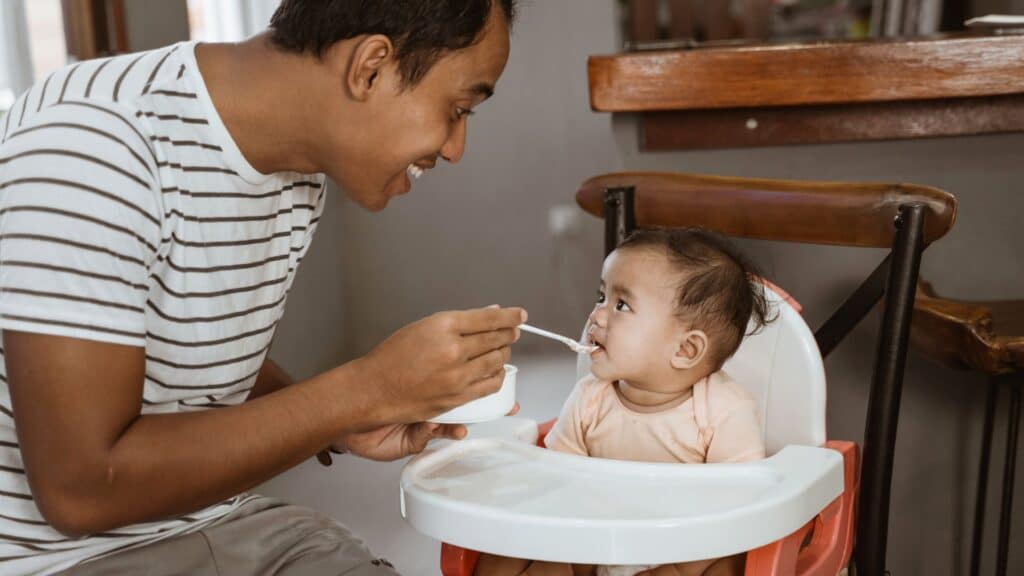 Father feeding the infant.