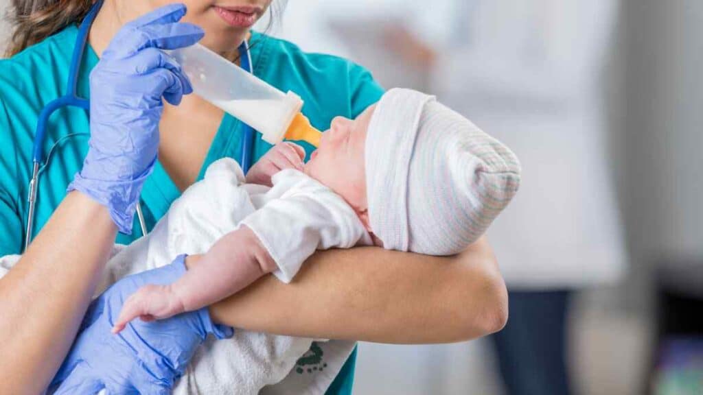 Nurse feeding the baby Breast Milk and Formula.