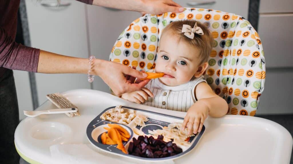 Infant eating vegetables.