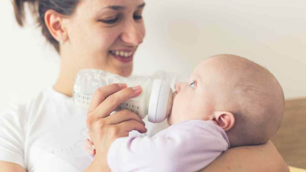 Feeding infant with milk formula.