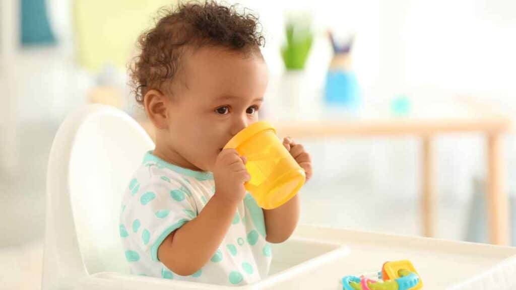 baby drinks in yellow sippy cup