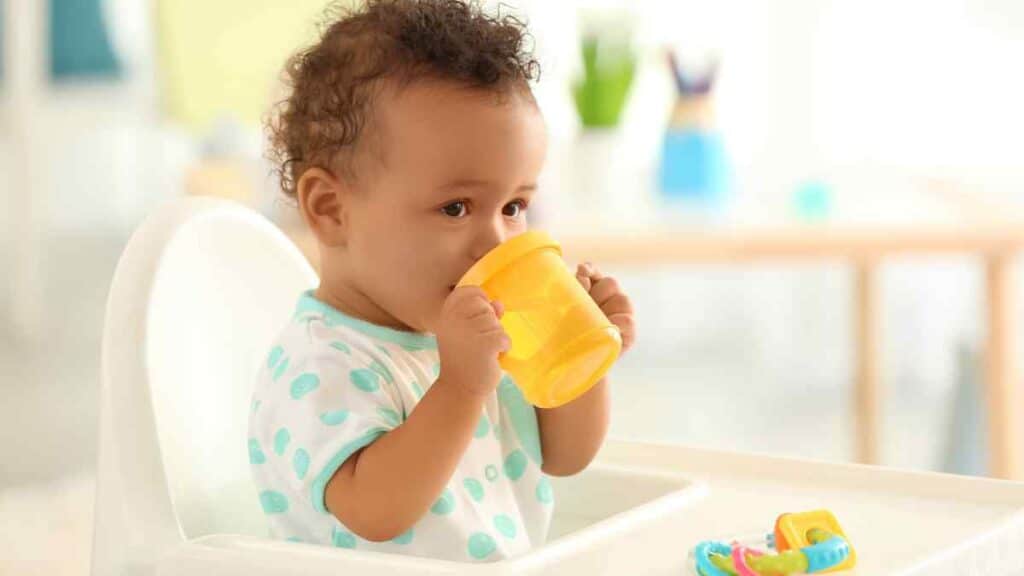 baby with yellow sippy cups