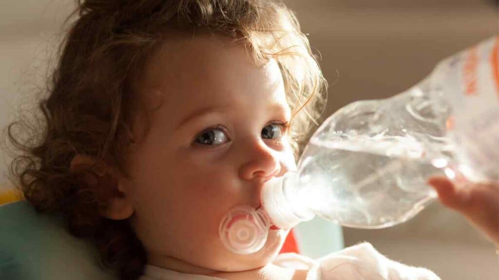 The baby is drinking clean water.