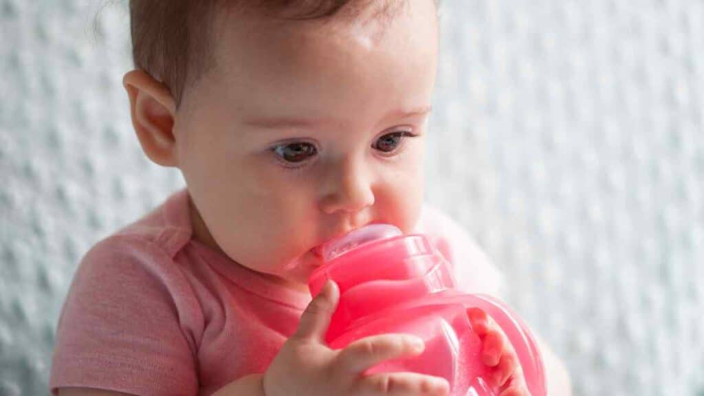 The baby with her pink sippy cup.