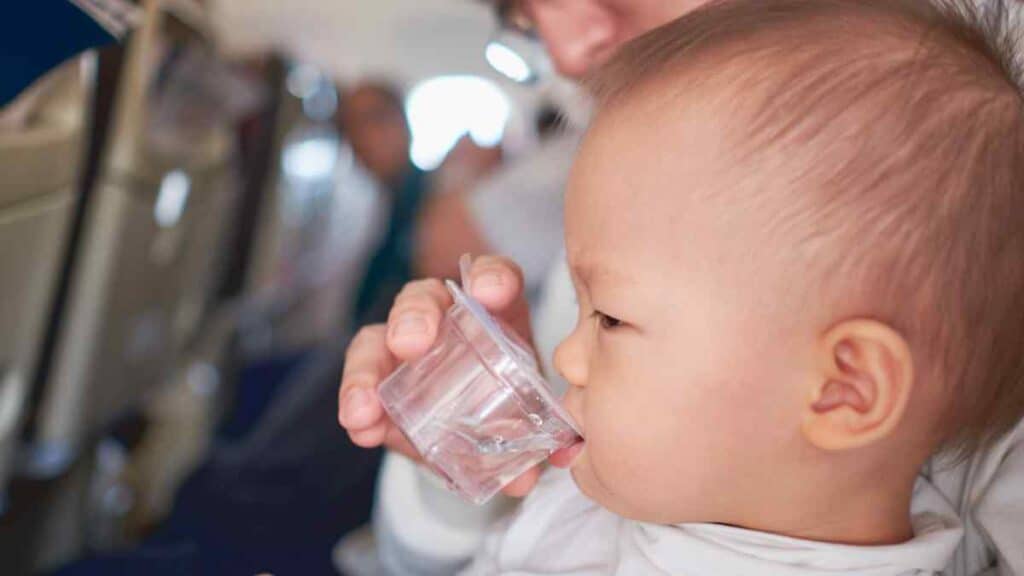 Baby drinks clear water.