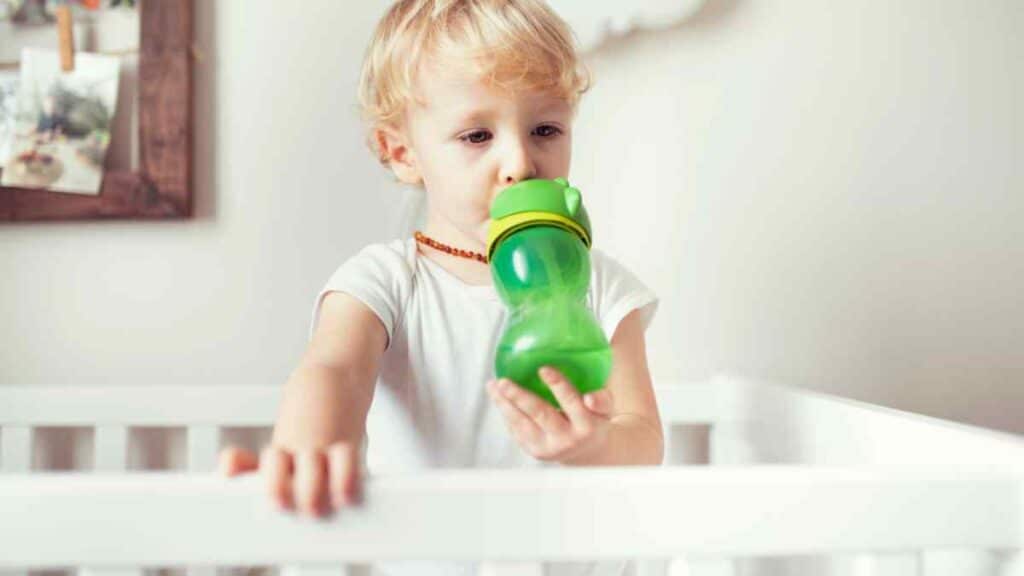 baby drinks in green bottle