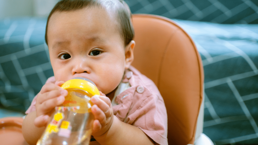 baby uses yellow sippy cup